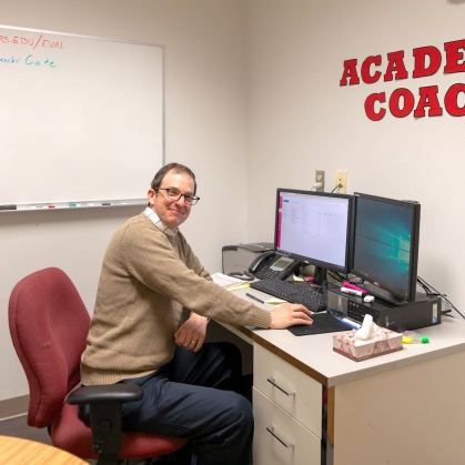 An academic coach works at a computer in the Learning Centers offices