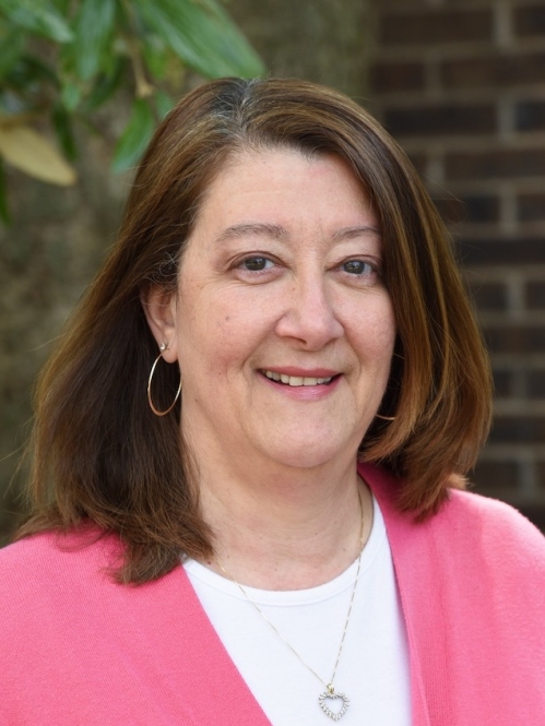 Marie Freibergs is wearing a pink cardigan.